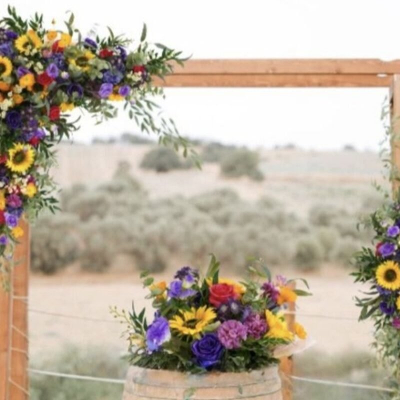 Sunflower and Purple Bloom Wedding Arch Flowers with Cascading Greenery and Rustic Charm